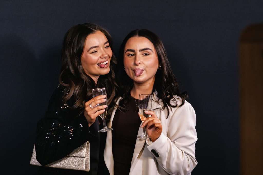 Two ladies posing for photos at a corporate party